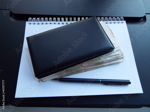 notebook and pen and money