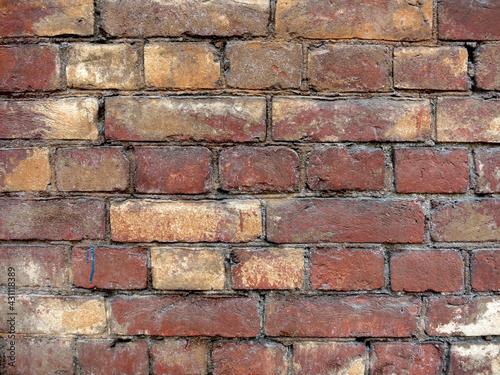 Red brick wall with yellow splinters