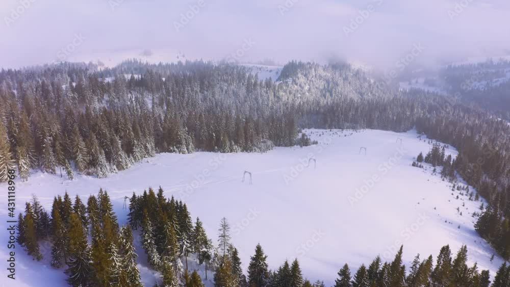 Steep mountain slopes covered with lush evergreen trees and snow-white fluffy snow with a long and old elevator slope for skiers and snowboarders, aerial UHD 4K video Steep mountain slopes covered with lush evergreen trees and snow-white fluffy snow with a long and old elevator slope for skiers and snowboarders, aerial UHD 4K video