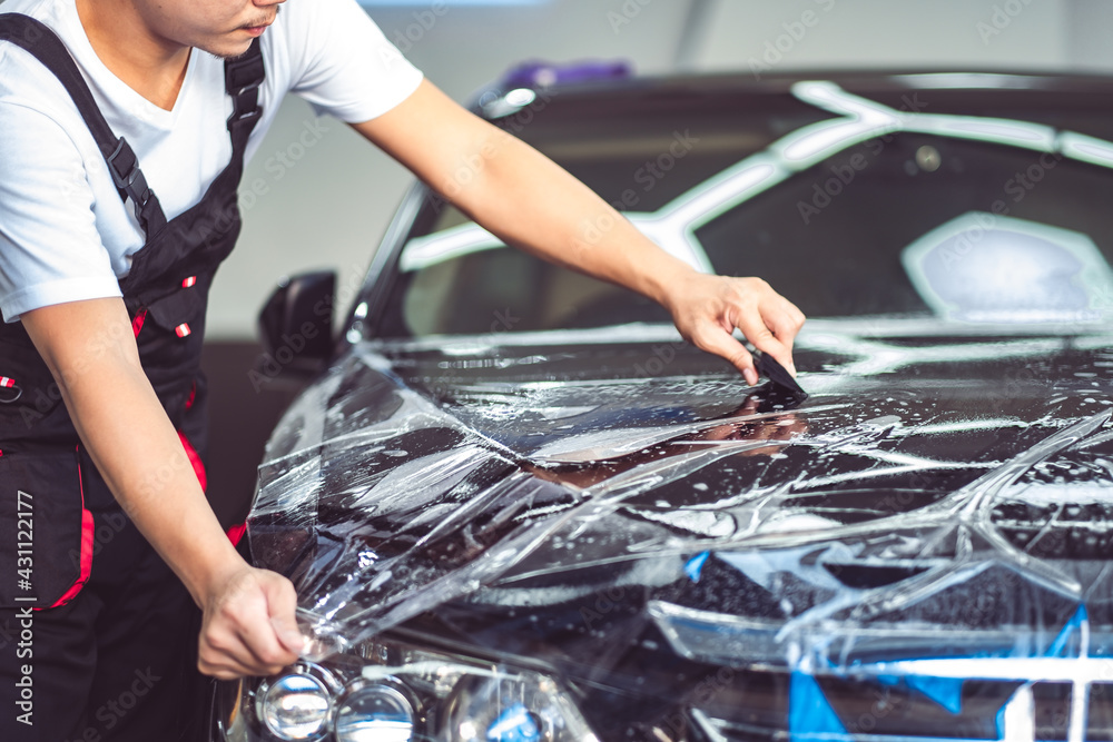 Paint protection film installation on door panel of luxury sports car