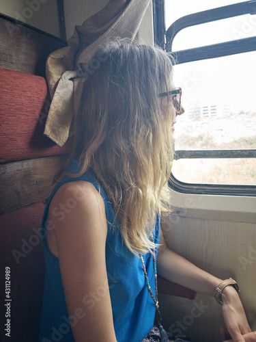 Woman tourist sitting in a vintage railway car wagon.