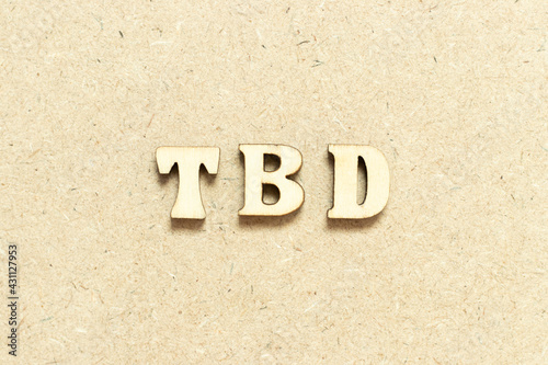 Alphabet letter in word TBD (Abbreviation of to be defined, discussed, determined, decided, deleted or declared) on wood background