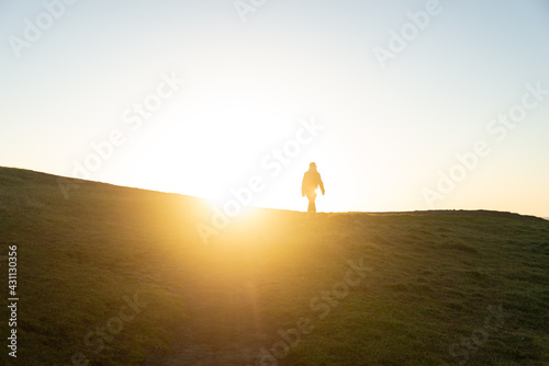 Silhouette of Person against Sunrise on a Hill. Lifestyle and Nature Concept © nicolas