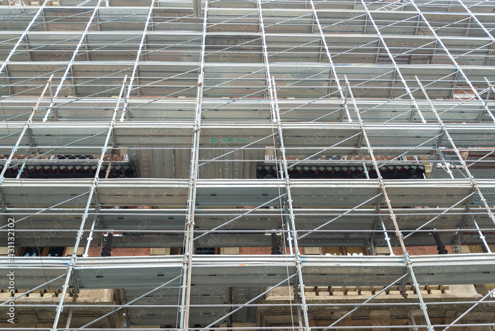 Perspective of a scaffolding structure on the facade of an ancient building in the centre of Milan, Italy. Perspective of a scaffolding structure on the facade of an ancient building in the centre of Milan, Italy.