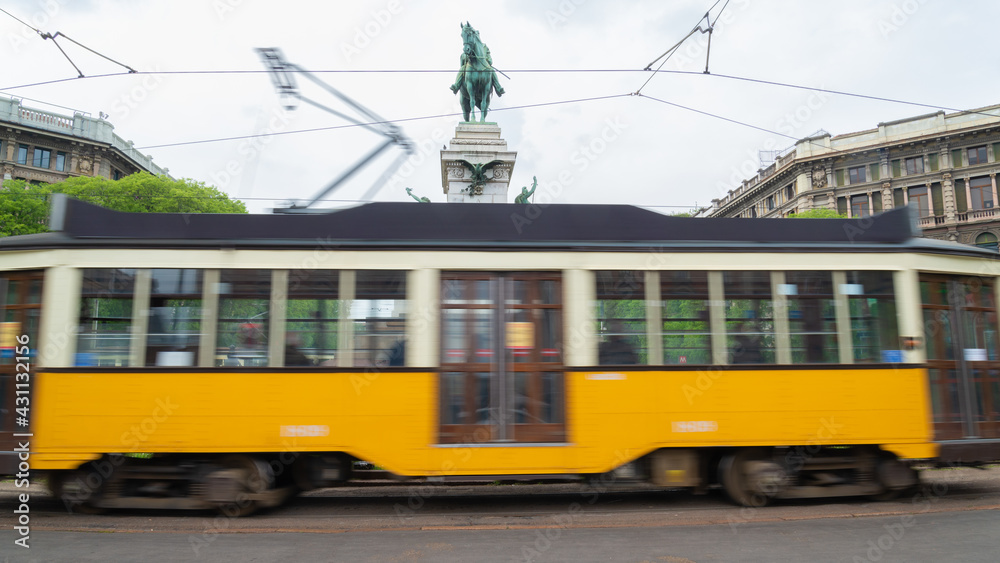 The famous tram in motion blur, an old typical way of public transport of the city. Horse statue in the background.