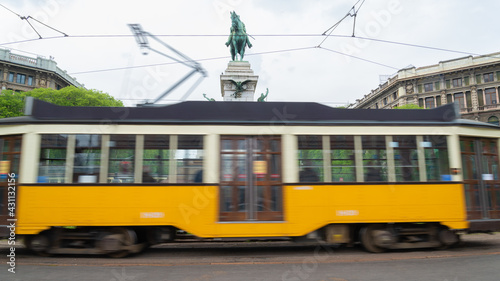 The famous tram in motion blur, an old typical way of public transport of the city. Horse statue in the background. photo