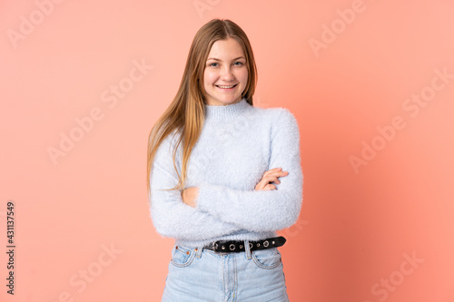 Teenager Ukrainian girl isolated on pink background keeping the arms crossed in frontal position