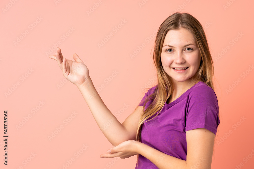 Teenager Ukrainian girl isolated on pink background extending hands to the side for inviting to come Teenager Ukrainian girl isolated on pink background extending hands to the side for inviting to come