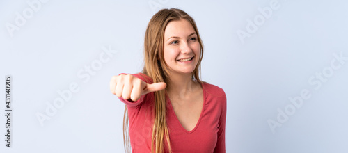 Teenager Ukrainian girl isolated on blue background giving a thumbs up gesture