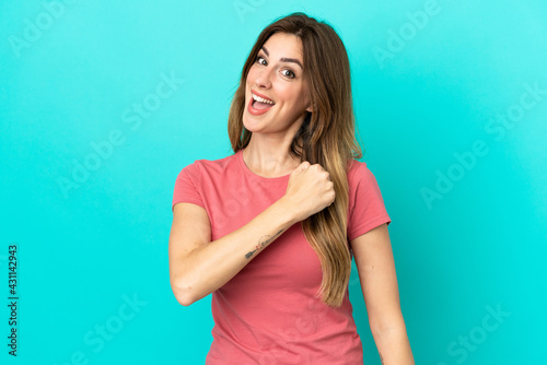 Young caucasian woman isolated on blue background celebrating a victory