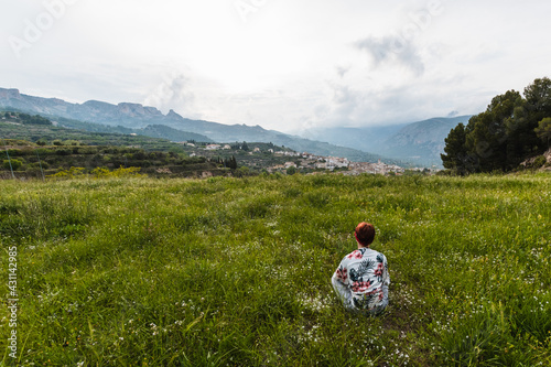 Woman relaxing in a beautiful meadow with a flowers shirt 
