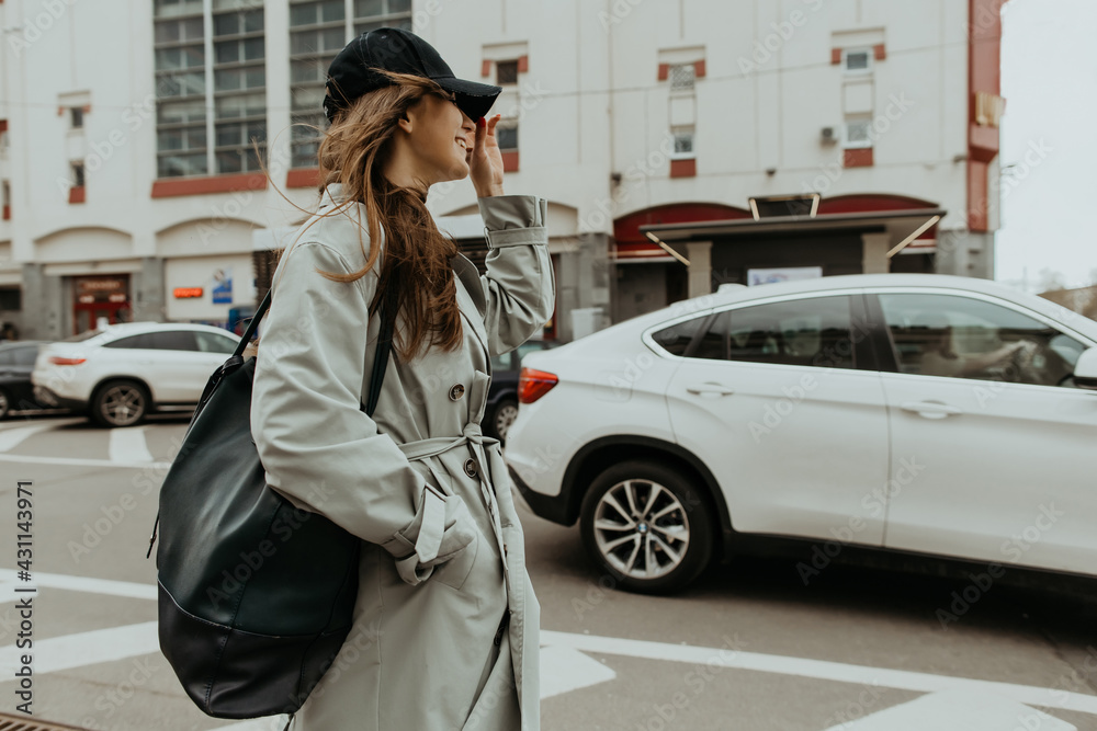 Fototapeta premium stylish girl in a trench walks around the city