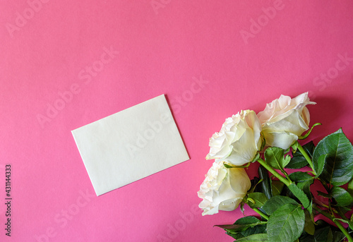 Postcard with three white roses on a pink background with hearts. Greeting card with the concept of flowers. Holiday greeting card. Top view, flat lying.