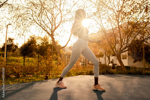 profile view of a Black woman silhouette exercing on street at sunset photo