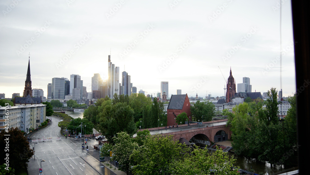 Naklejka premium Skyline von Frankfurt über den Abend vom Sonnenuntergang bis zur Dämmerung und Abendröte mit den Hochhäusern im Hintergrund und der Alten Brücke mit neuem Portikus im Vordergrund