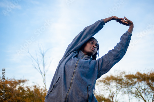 low angle view of a black woman streching her arms in the air. Great copy space