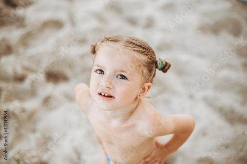 Beautiful and expressive little girl posing for a photo by the ocean