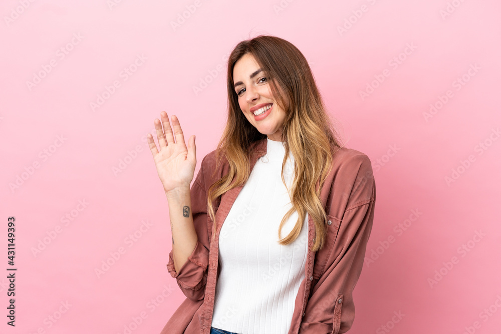 Caucasian woman isolated on pink background saluting with hand with happy expression Caucasian woman isolated on pink background saluting with hand with happy expression