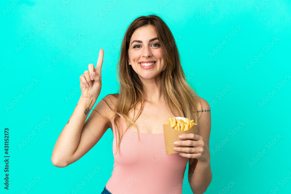 Caucasian woman holding fried chips isolated on blue background pointing up a great idea Caucasian woman holding fried chips isolated on blue background pointing up a great idea