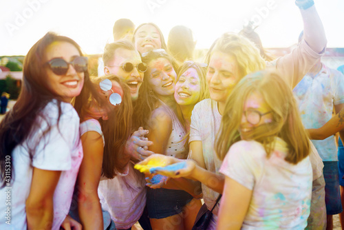 Teenagers Friends have fun at the holi festival. Beach Party. Celebrating traditional indian spring holiday. Friendship, Leisure, Vacation, Togetherness.
