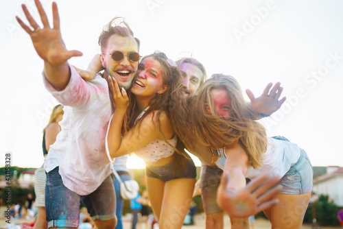 Teenagers Friends have fun at the holi festival. Beach Party. Celebrating traditional indian spring holiday. Friendship, Leisure, Vacation, Togetherness.