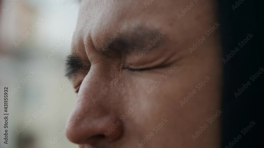 close-up of a human eye. The Asian guy narrows his eyes tightly and a tear runs from his eye. The eyes are watery. Asian eye shape. A man looks at the city street. sad emotional state close-up of a human eye. The Asian guy narrows his eyes tightly and a tear runs from his eye. The eyes are watery. Asian eye shape. A man looks at the city street. sad emotional state
