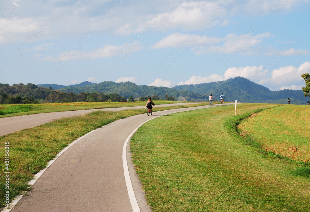 Sport activity ride bicycle on bicycle lane in the parks with Cloud blue sky at singha park , chiang rai , thailand - Travel park and Outdoor Sport activity ride bicycle on bicycle lane in the parks with Cloud blue sky at singha park , chiang rai , thailand - Travel park and Outdoor