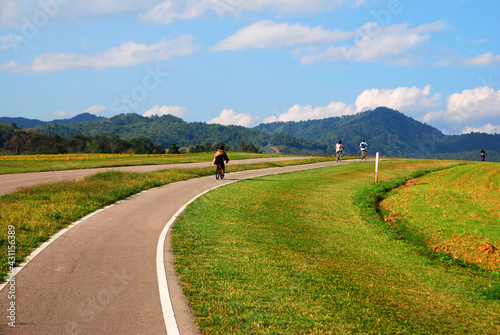Photos Sport activity ride bicycle on bicycle lane in the parks with Cloud blue sky at