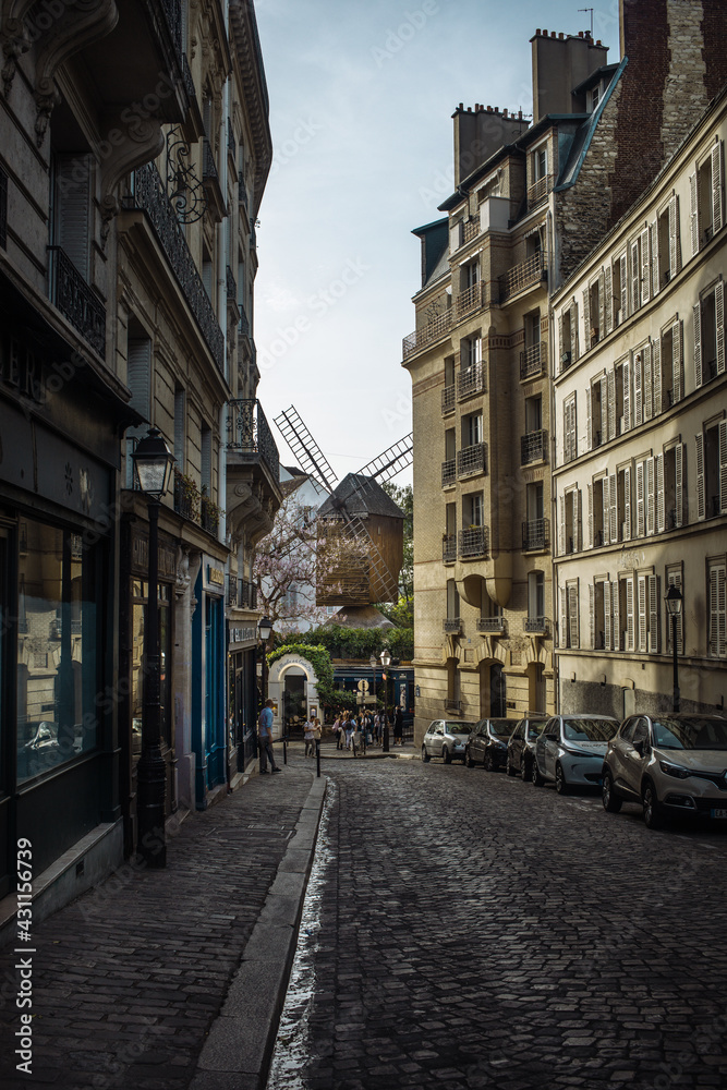 cobblestone street and old moulin in montmartre paris 