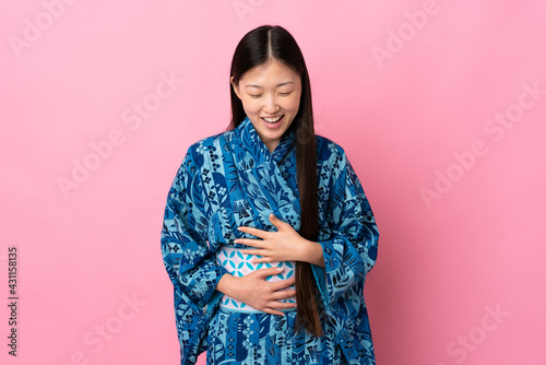 Young Chinese girl wearing kimono over isolated background smiling a lot