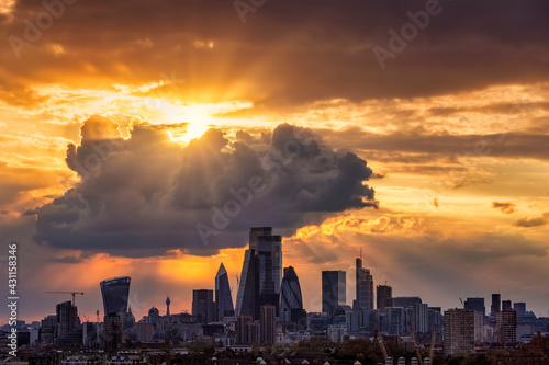 Dramatic sunset sky with clouds and sunrays over the urban skyline of the City of London, United Kingdom