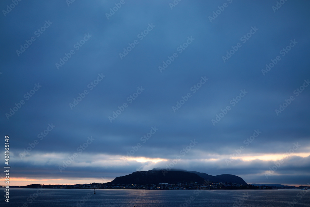 clouds over the sea and island, nordic weather, sunset, horizon over the sea