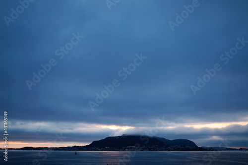 clouds over the sea and island, nordic weather, sunset, horizon over the sea