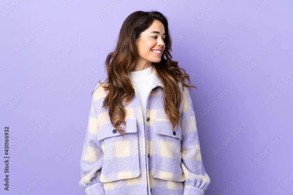 Woman over isolated purple background looking side Woman over isolated purple background looking side