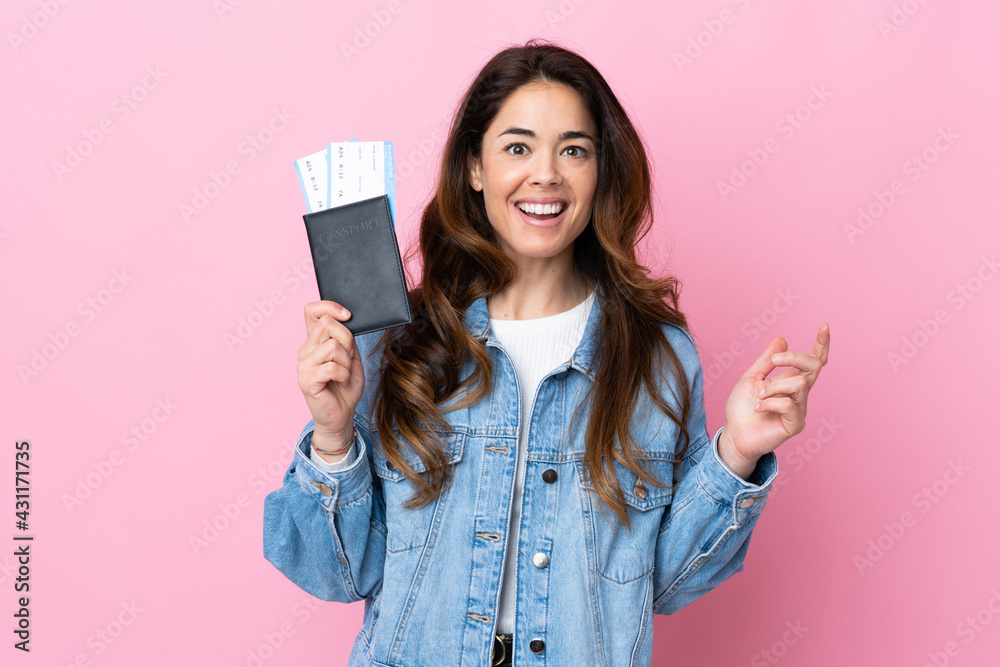 Woman over isolated blue background happy in vacation with passport and plane tickets Woman over isolated blue background happy in vacation with passport and plane tickets