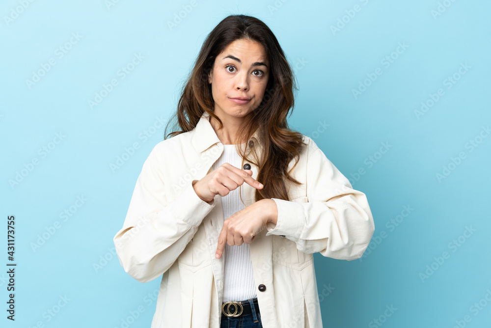 Woman over isolated background making the gesture of being late Woman over isolated background making the gesture of being late