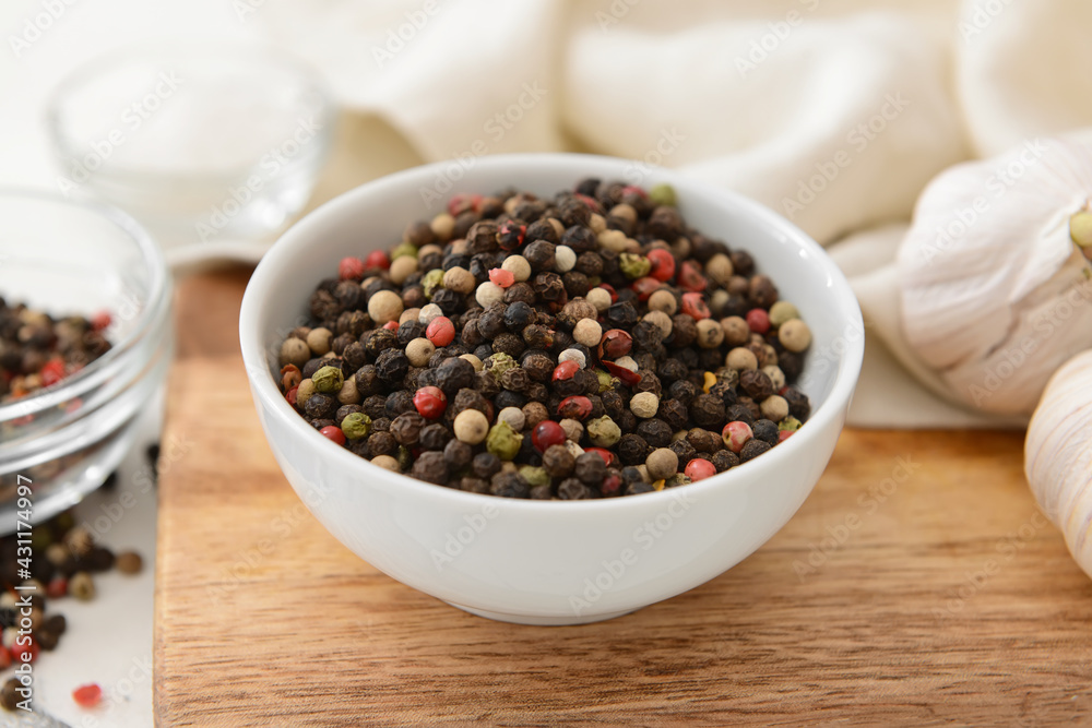 Bowl with peppercorns on wooden background Bowl with peppercorns on wooden background