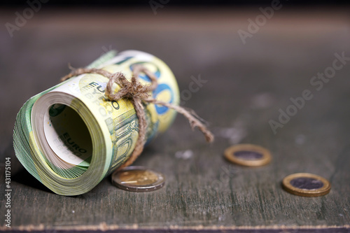 Euro close-up. Money macro. Banknotes are rolled up by a roll with rope. Cash. Banknotes twisted into a roll. European currency. 