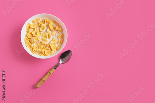 Bowl with tasty cornflakes on color background