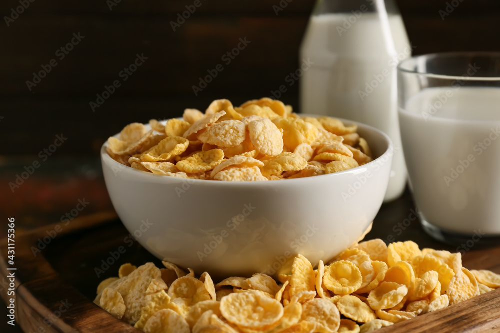 Glass of milk and bowl with tasty cornflakes on grunge background Glass of milk and bowl with tasty cornflakes on grunge background