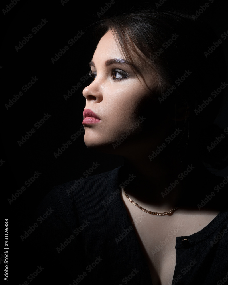 portrait of a girl sideways on a black background.copy space portrait of a girl sideways on a black background.copy space