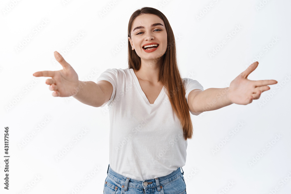 Smiling friendly female host, stretch out hands and inviting, reaching for hug, welcome guests, wants to hug and embrace you, welcoming friends, standing over white background Smiling friendly female host, stretch out hands and inviting, reaching for hug, welcome guests, wants to hug and embrace you, welcoming friends, standing over white background