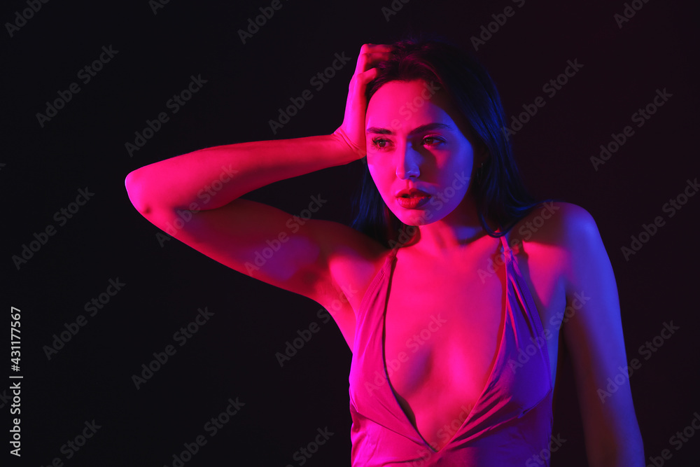 Toned portrait of beautiful young woman on dark background Toned portrait of beautiful young woman on dark background