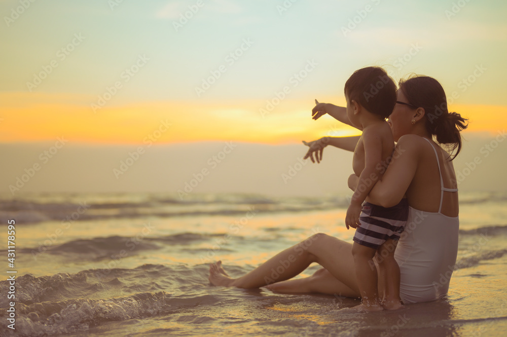 Happy family resting at beach in summer, Mother and som feet at the sea foam at the sunlight water is moving