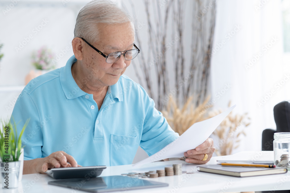 Senior man calculating taxes at home.