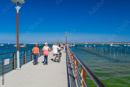 Tourists walking with their bikes on the jetty of Bélisaire in Cap Ferret, Arcachon Bay photo