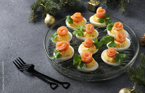 Stuffed eggs with salted salmon and cheese. Delicious festive snack on a dark background photo