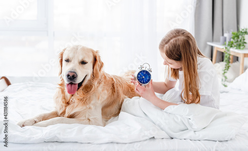 Girl with golden retriever dog in the bed