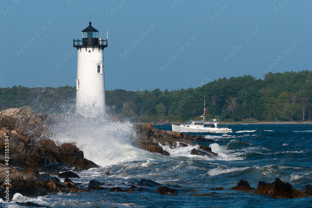 Portsmouth Lighthouse Guides Fishing Boat Through Rough Surf as Waves Crash on Rocky Shore