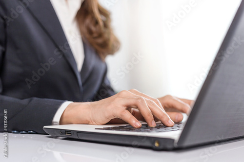 Female business hands typing on laptop computer, close-up